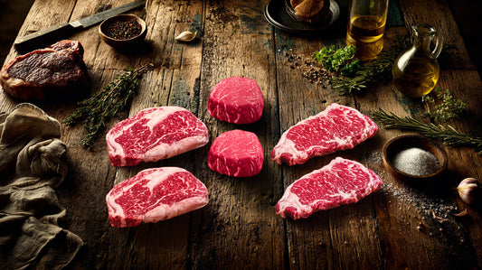 Marbled Meatery Corporate steak gift package showcasing premium ribeye, filet, and strip steaks on wooden board, ideal for executive gifting and client appreciation.