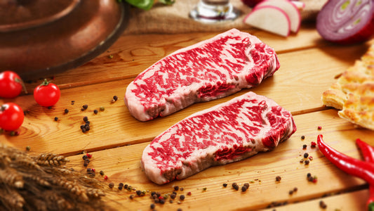 Marbled Meatery Date Night steak package featuring three premium New York strip steaks with intense marbling on rustic wooden board, perfect for romantic dinners at home.