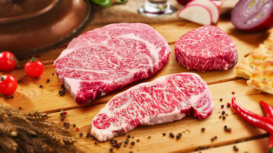 Marbled Meatery Japanese Wagyu sampler package displaying filet, ribeye, and strip steaks with intense marbling from elite Japanese ranches, ultimate luxury steak gift.
