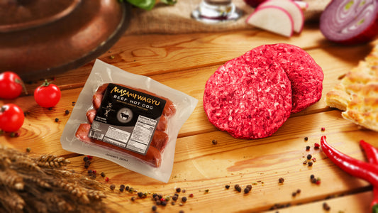 Marbled Meatery Tailgating package with Wagyu hot dogs and premium burger patties on cutting board, ideal for game day celebrations and backyard grilling.